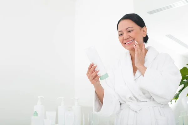 Mulher sênior alegre usando cosméticos no centro de bem-estar — Fotografia de Stock