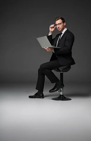 Hombre de negocios serio escribiendo en el ordenador portátil —  Fotos de Stock