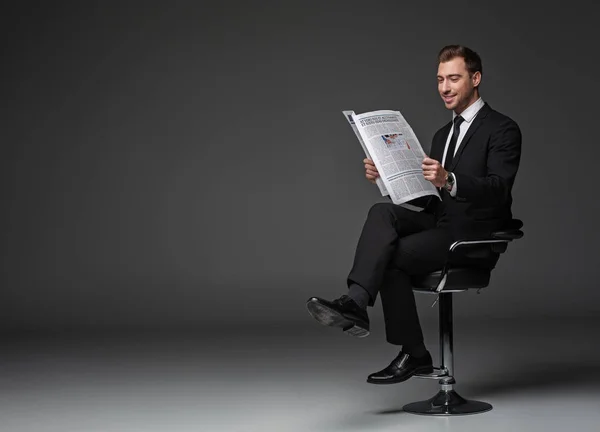 椅子の上の新聞を読んで喜んでいる男性 — ストック写真
