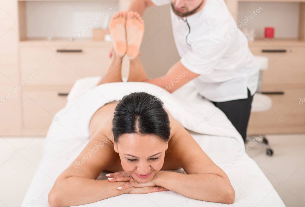 Pleased woman getting a massage at spa