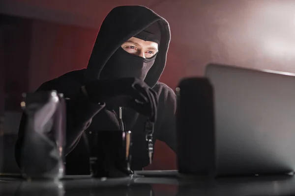 Ordenado ladrón de computadoras manteniendo la llave en la mano — Foto de Stock