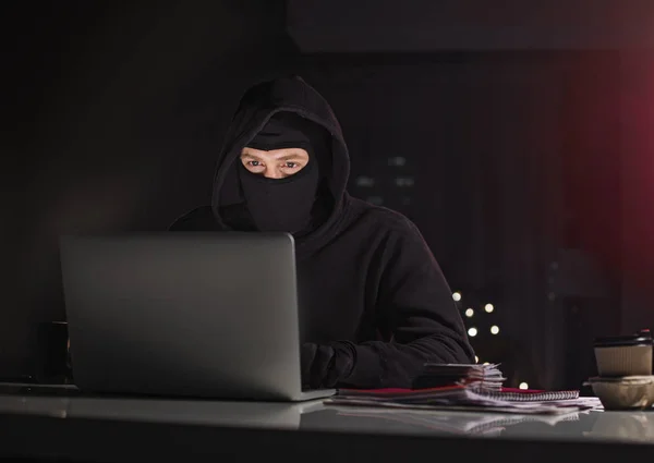 Serious computer fraudster noting in laptop — Stock Photo, Image