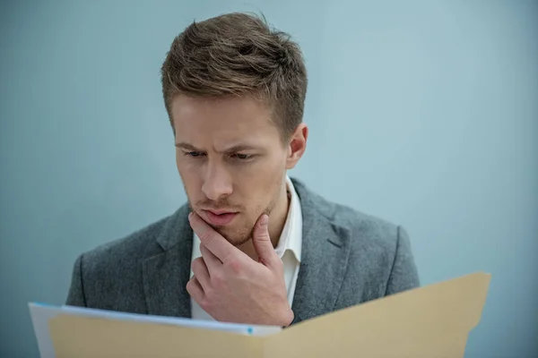 Pensive professional employee is holding documents — Stock Photo, Image