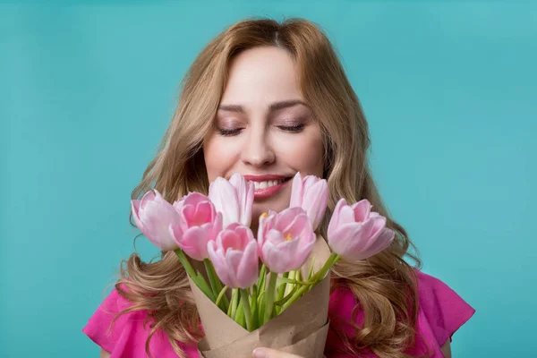 Jovem feliz desfrutando cheiro de tulipas — Fotografia de Stock