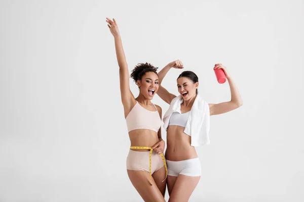 Happy girls admiring their slender bodies — Stock Photo, Image