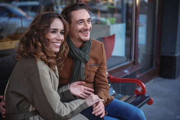 Šťastný muž a žena na lavičce v městě — Stock fotografie