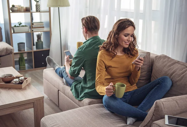 Allegro uomo e donna che si riposano con gli smartphone — Foto Stock