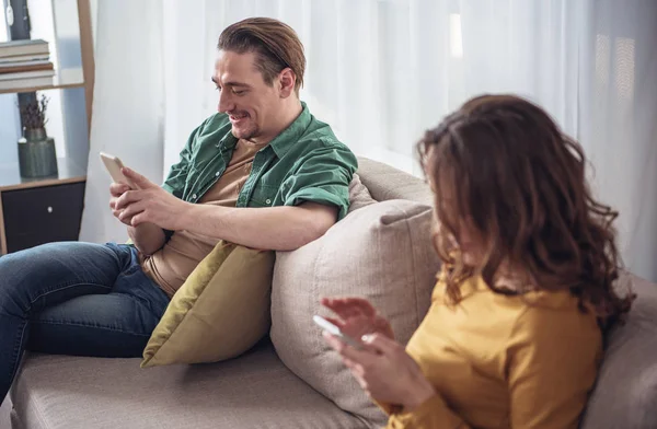 Pasangan menikah yang gembira menggunakan smartphone di rumah — Stok Foto