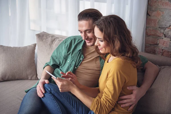 Happy pecinta menghibur dengan gadget di ruang tamu — Stok Foto