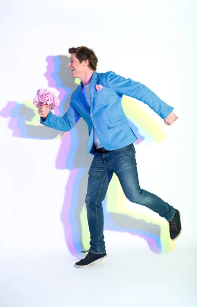 Hombre alegre corriendo con flores en la mano — Foto de Stock
