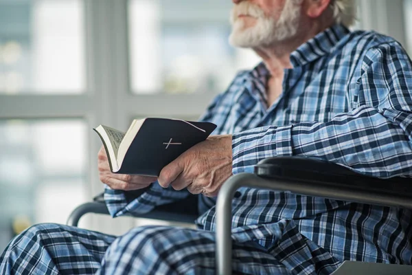 Sénior masculino lendo o livro sagrado no quarto — Fotografia de Stock