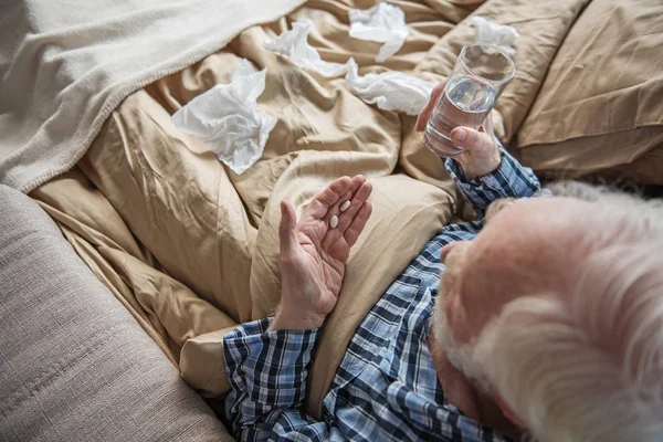 Hombre mayor tomando medicamentos en casa — Foto de Stock