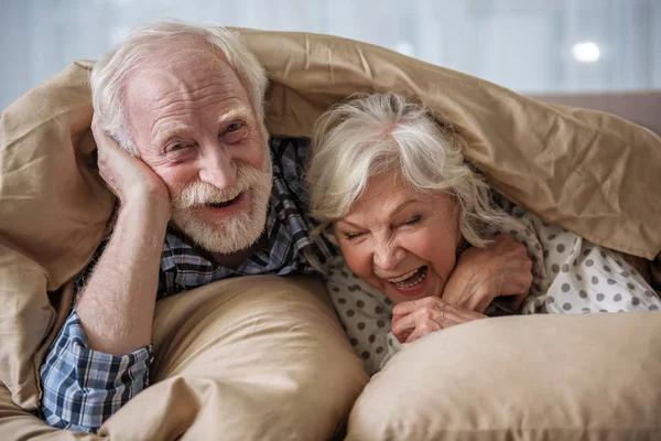 Feliz marido y mujer mayores relajándose en el dormitorio — Foto de Stock