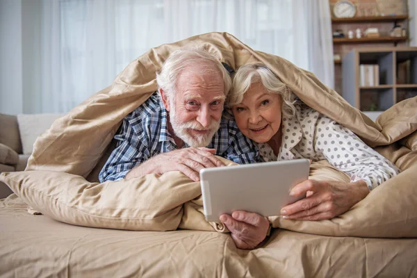 Glad gammal gift par har resten i sängen — Stockfoto