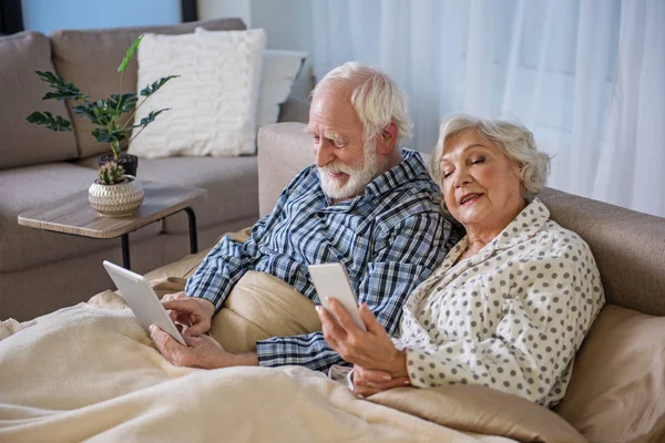 Relaxed husband and wife sitting in bed — Stock Photo, Image