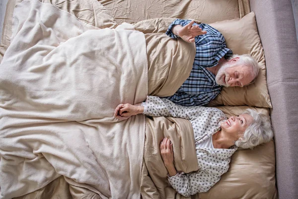 Pensionistas felices acostados en la cama — Foto de Stock