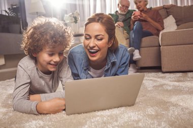 Giden anne ve çocuk cihaz izlerken