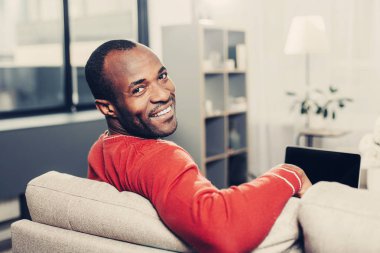 Mutlu erkek kişi kapalı bilgisayar kullanarak