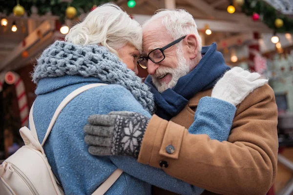 Ласковые пожилые мужчина и женщина обнимаются снаружи — стоковое фото
