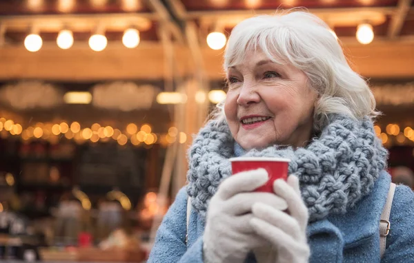 Feliz señora madura calentándose por la bebida caliente al aire libre — Foto de Stock