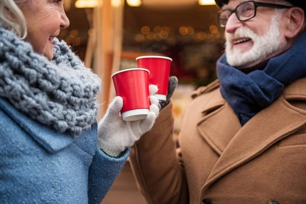 Feliz pareja de ancianos tazas tintineo de bebida caliente —  Fotos de Stock
