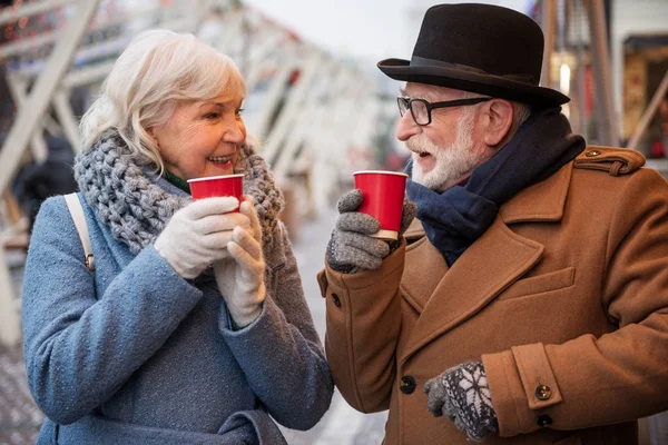 Рад, что взрослый мужчина и женщина согреваются горячим напитком на улице — стоковое фото
