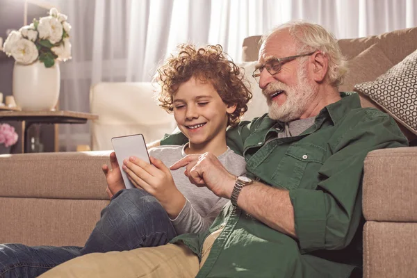 Веселий дідусь і хлопчик дивиться на мобільний — стокове фото
