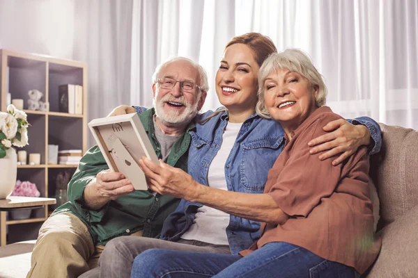 Boldog nagyszülők és női gazdaság fénykép — Stock Fotó