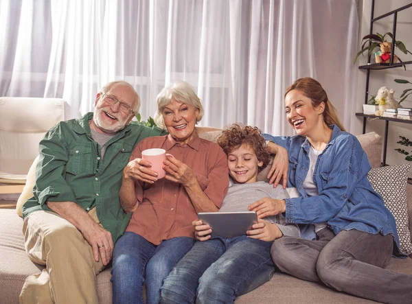 Familiares radiantes descansando en el sofá — Foto de Stock