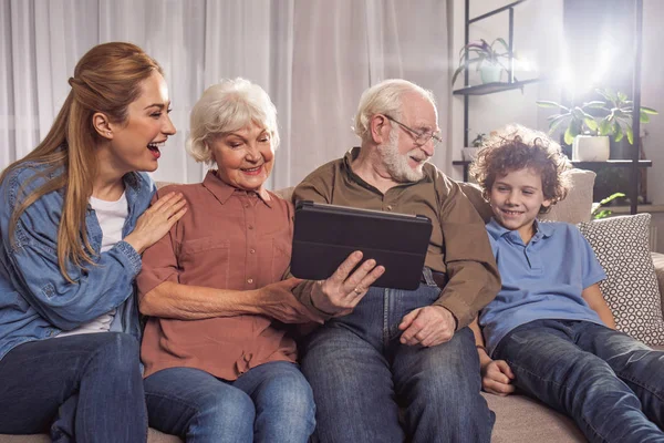 Счастливая семья смотрит на электронный планшет — стоковое фото