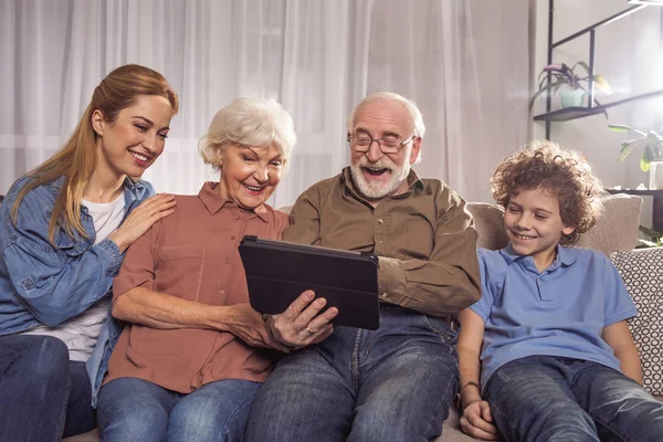 Glückliche Verwandte schauen am digitalen Gerät zu — Stockfoto