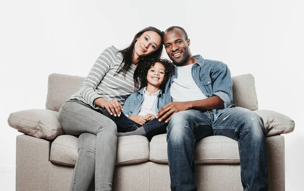 Genitori e figlia riposano sul divano e sorridono — Foto Stock