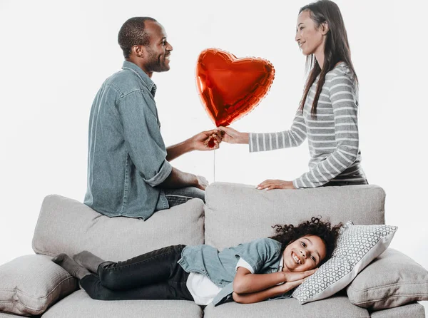 Anak yang senang berbaring di sofa dekat orang tua — Stok Foto