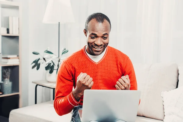 Sorrindo homem jubilando na frente do laptop — Fotografia de Stock