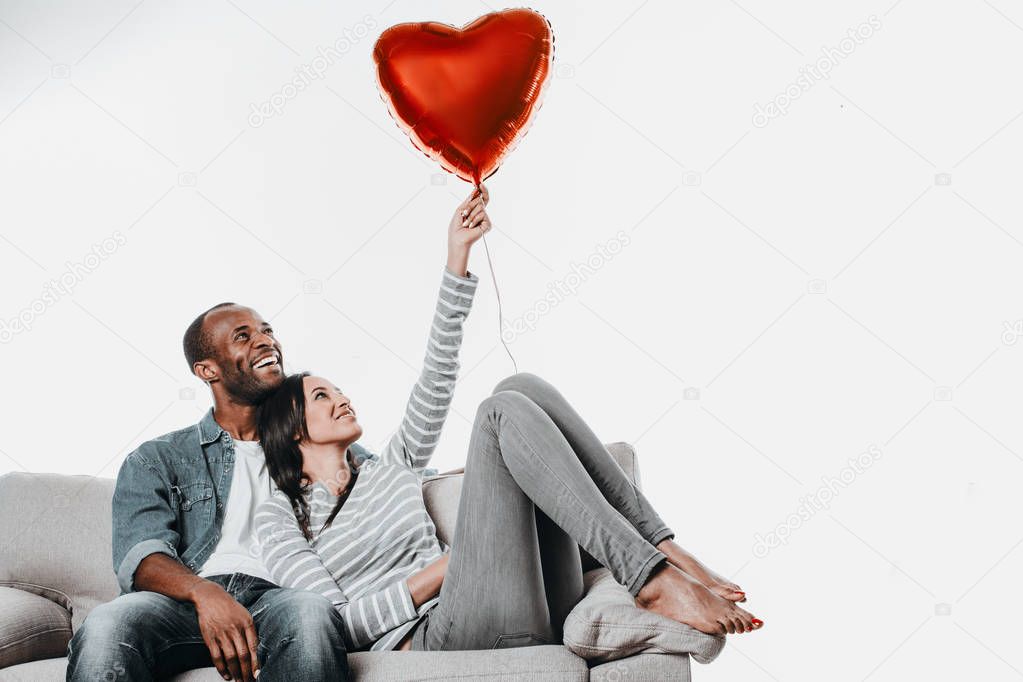 Couple entertaining with air balloon on sofa