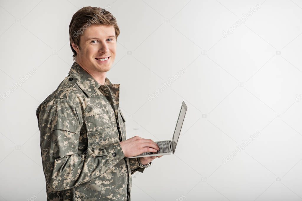 Glad male soldier surfing the internet