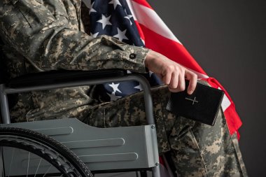 Handicapped military man holding book clipart
