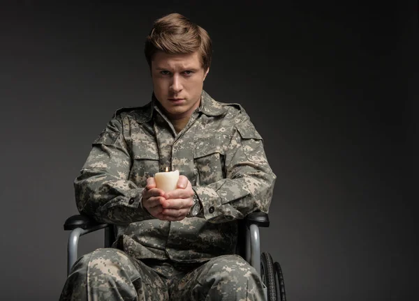 Molesto hombre militar discapacitado que tiene vela en las manos — Foto de Stock