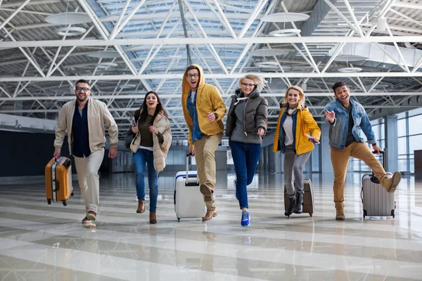 Zufriedene Reisende mit Gepäck in der Terminalhalle — Stockfoto