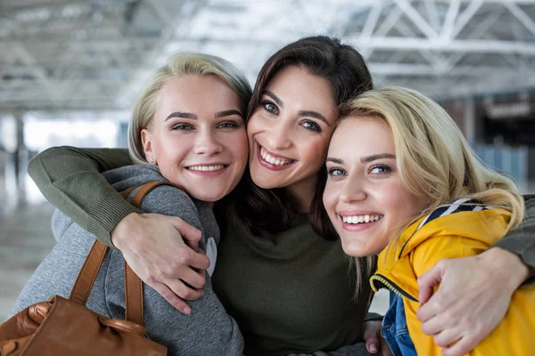 Mujeres sonrientes de pie en abrazo —  Fotos de Stock