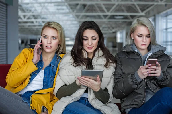 Meninas tranquilas relaxando com diferentes gadgets — Fotografia de Stock