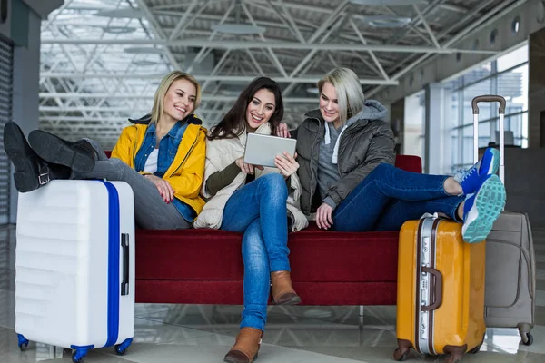 Happy women using gadget at the airport