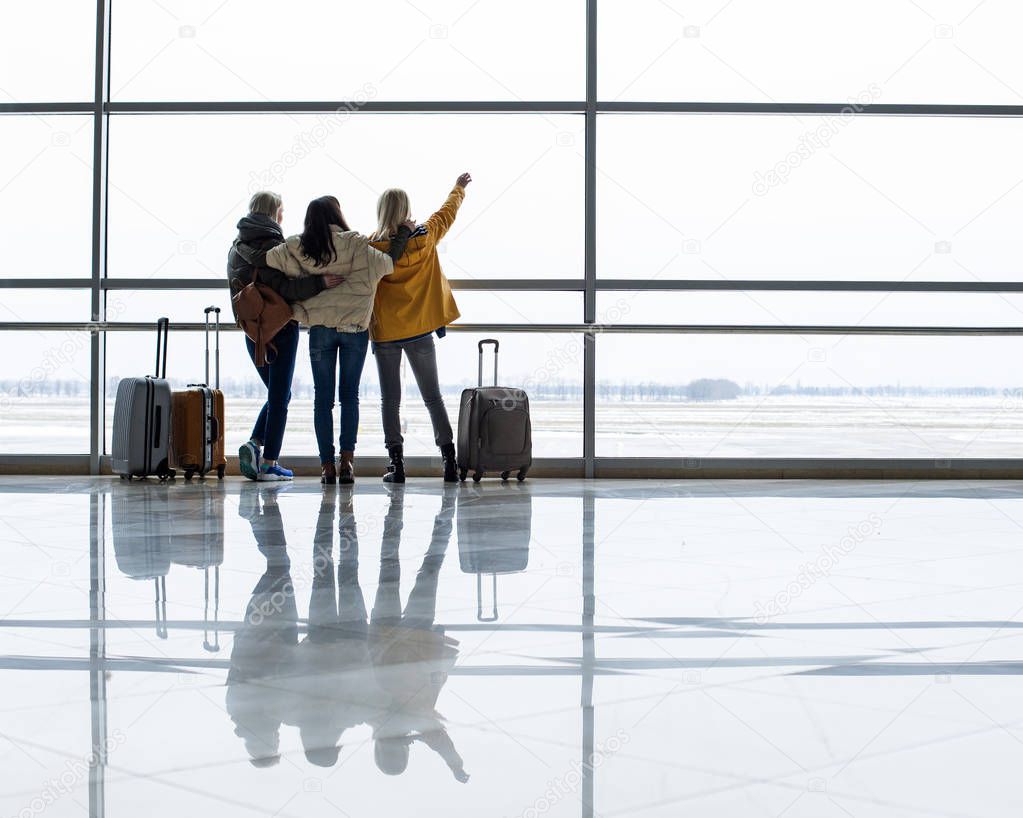 Female tourists looking at planes through window