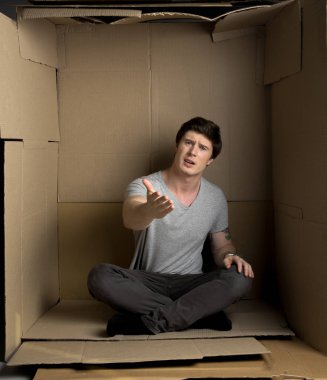 Kızgın genç adam kağıt oda içinde negatif duygular ifade