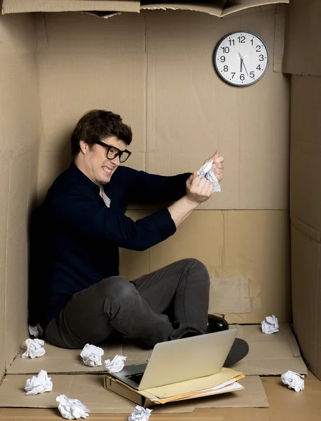 Trabalhador irritado está rasgando papel dentro de pequena caixa de papelão — Fotografia de Stock