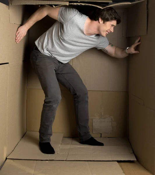 Guy is feeling discomfort inside paper container — Stock Photo, Image