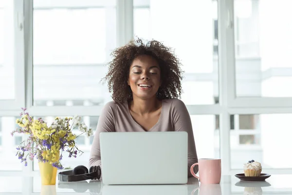 Szczęśliwa kobieta pracując na komputerze przy stole — Zdjęcie stockowe