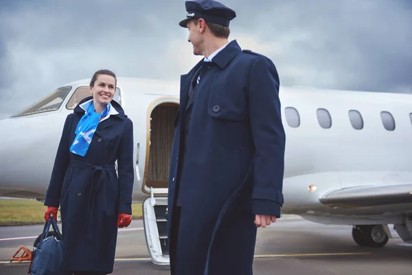 Fröhliche Stewardess im Gespräch mit Flieger — Stockfoto