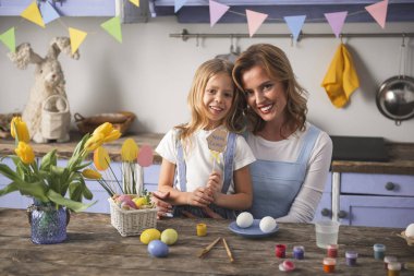 Mutlu anne ve kızı mutfakta poz