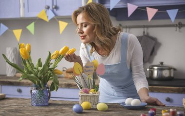 Memnun kadın mutfakta çiçek kokulu